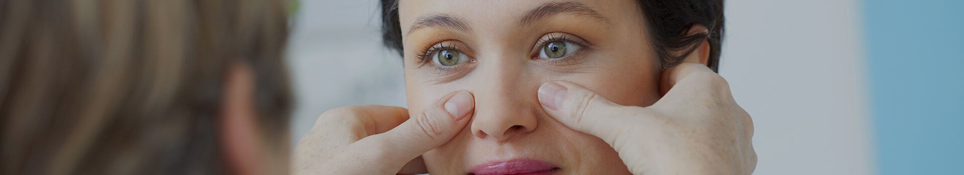Physician hold female patient's face to check sinus pressure