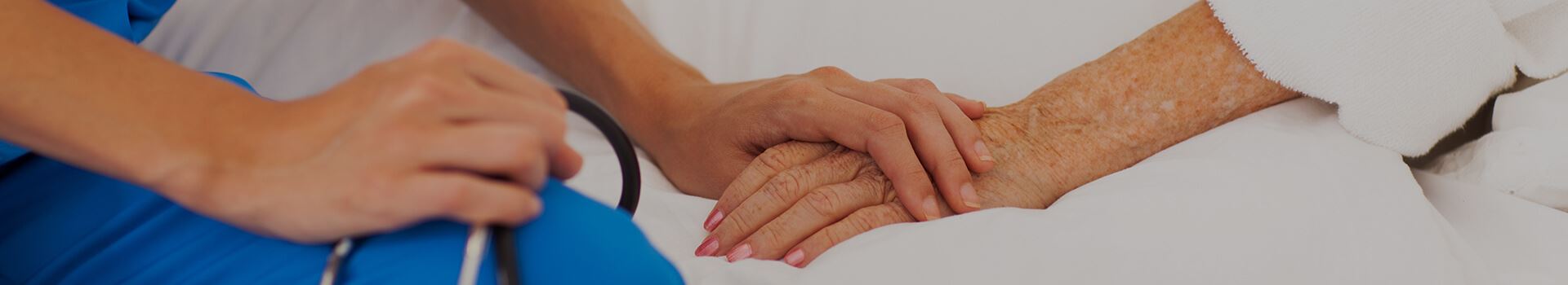 nurse holding elderly patient's hand