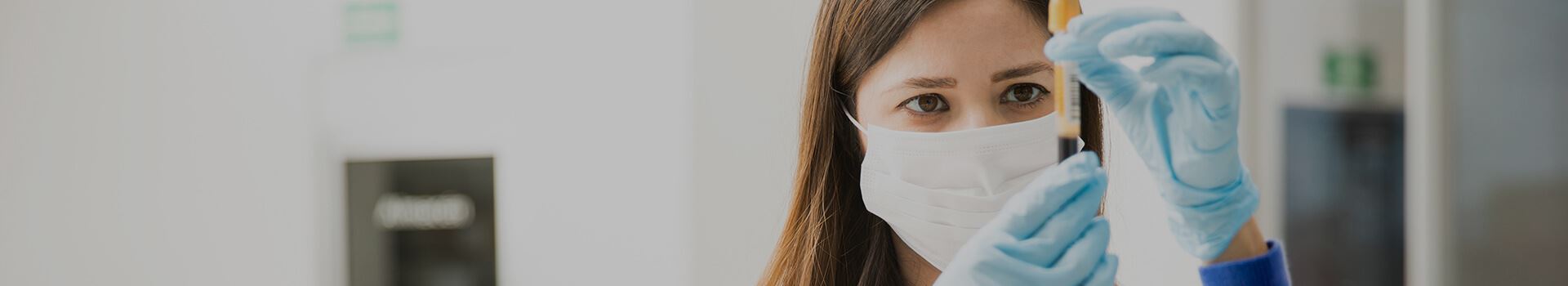 doctor with mask on reading test tube